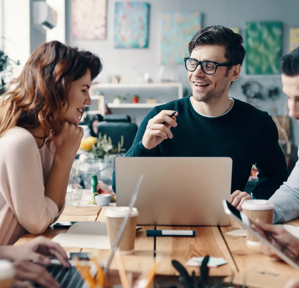 Team collaborating at a table with laptop